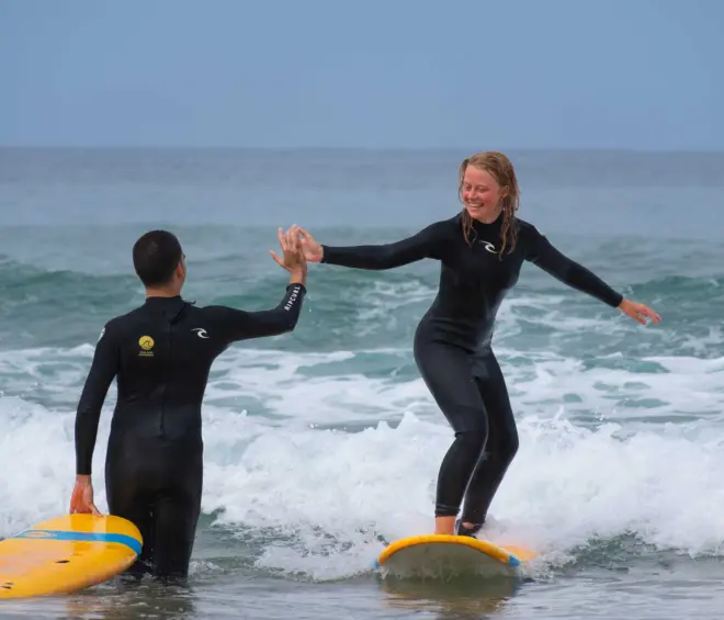 Happy surfer catching her first white wash
